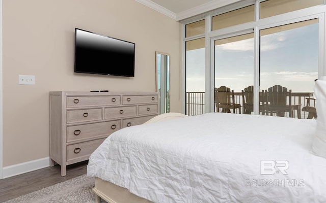 bedroom with hardwood / wood-style flooring, access to outside, and ornamental molding