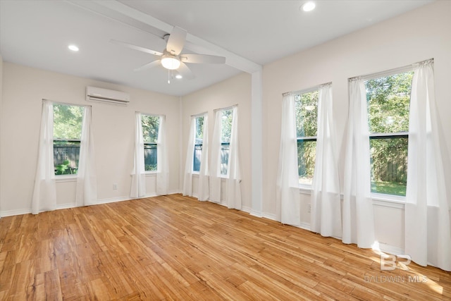 empty room with light wood finished floors, a wealth of natural light, and recessed lighting