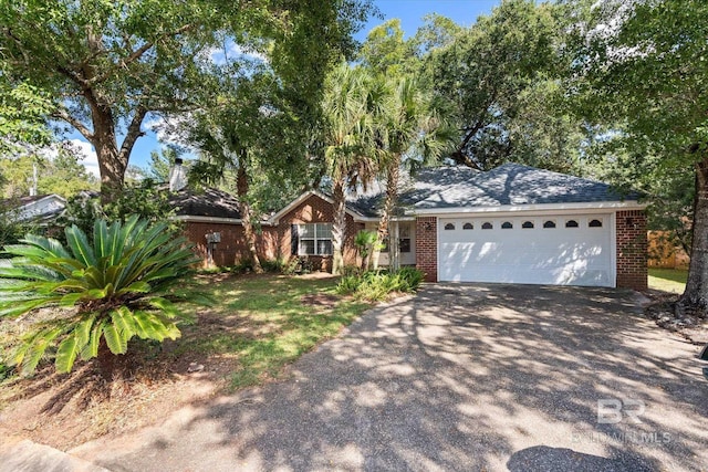 ranch-style home with aphalt driveway, an attached garage, and brick siding