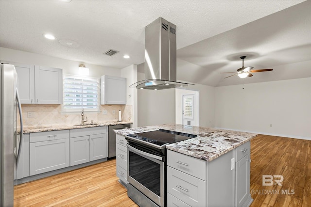 kitchen featuring tasteful backsplash, visible vents, appliances with stainless steel finishes, extractor fan, and a sink