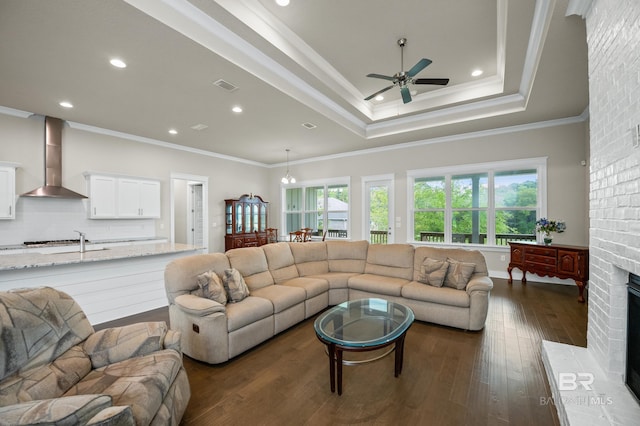 9377 Diamante Blvd, Daphne, AL 36526 - living area featuring crown molding, a tray ceiling, a ceiling fan, visible vents, and dark wood-style floors