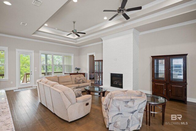 9377 Diamante Blvd, Daphne, AL 36526 - living area with visible vents, a ceiling fan, dark wood finished floors, crown molding, and a tray ceiling