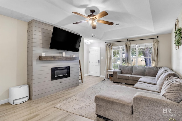 221 Howard Cir, Gulf Shores, AL 36542 - living area featuring a raised ceiling, wood finished floors, a large fireplace, and a ceiling fan