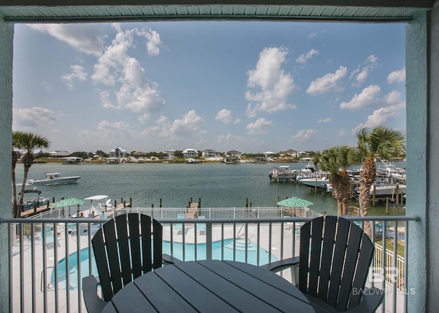 balcony featuring a water view and a community pool