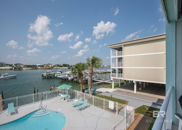 view of pool with a water view, a patio, and a boat dock