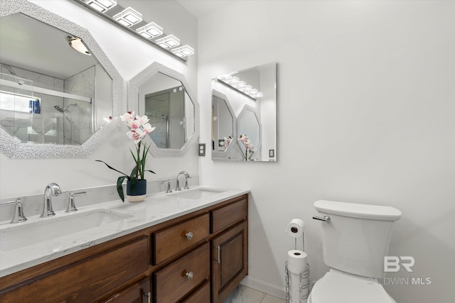 full bathroom with double vanity, toilet, a shower stall, and a sink