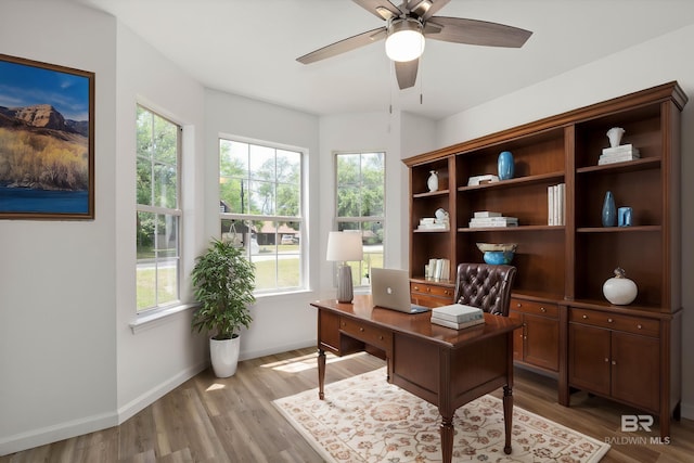 home office with baseboards, ceiling fan, and wood finished floors
