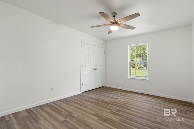 spare room featuring baseboards, a ceiling fan, and wood finished floors