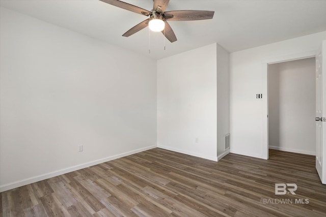 empty room with visible vents, wood finished floors, baseboards, and ceiling fan