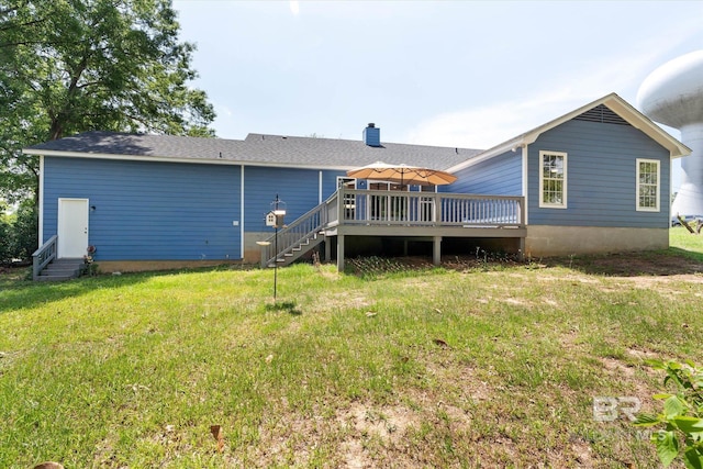 rear view of house with a lawn, a wooden deck, entry steps, and stairway