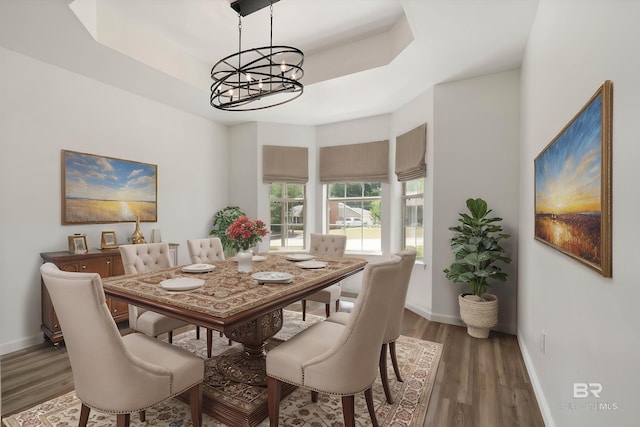 dining area with baseboards, an inviting chandelier, and wood finished floors