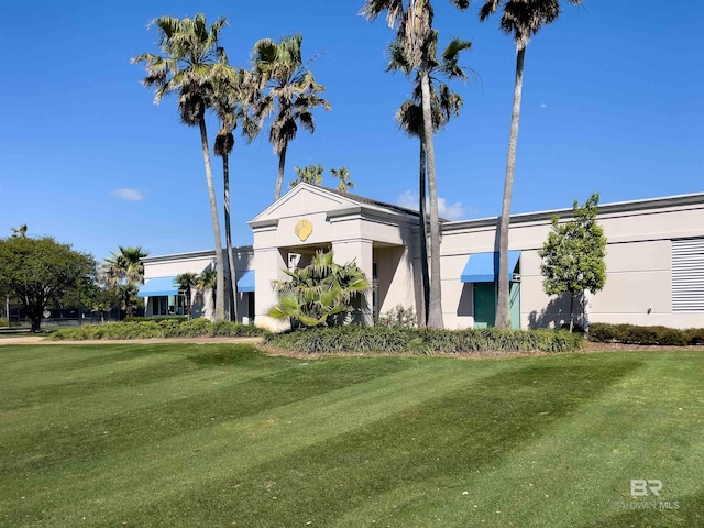exterior space with stucco siding and a front yard
