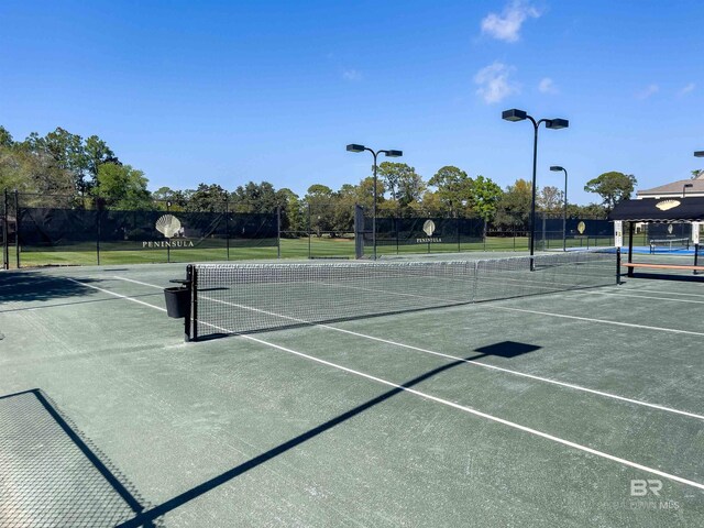 view of tennis court featuring fence