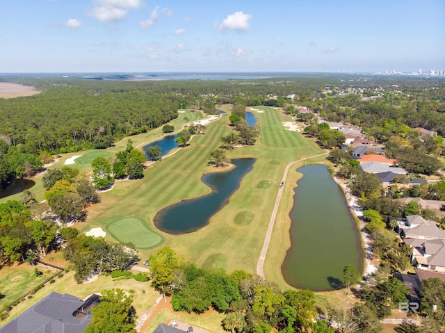 drone / aerial view with view of golf course, a water view, and a forest view