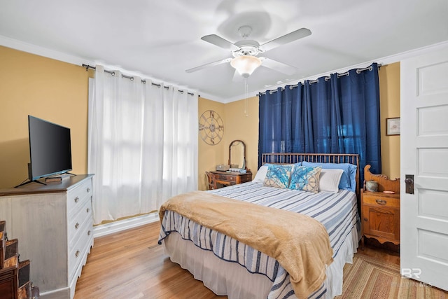 bedroom featuring light wood-style floors, ornamental molding, and a ceiling fan