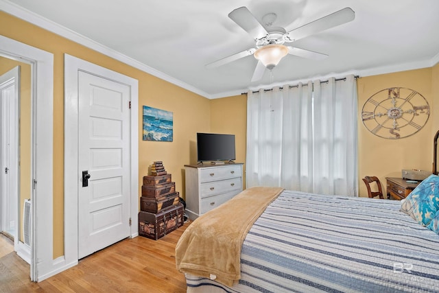 bedroom with ornamental molding, light wood finished floors, and a ceiling fan