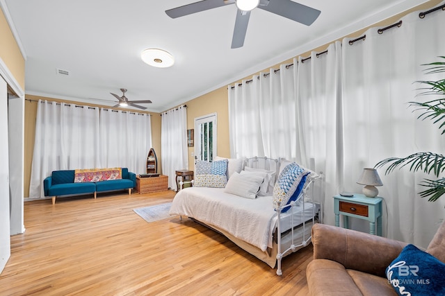 interior space featuring crown molding, visible vents, ceiling fan, and wood finished floors