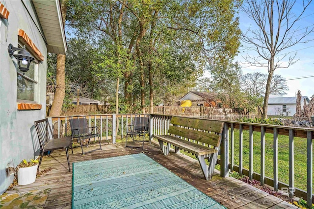 wooden terrace with a lawn and a fenced backyard