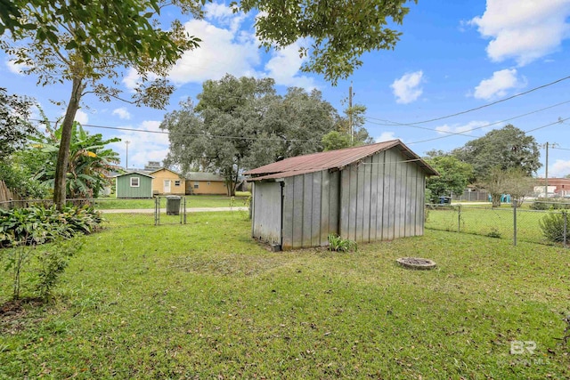 view of yard featuring an outbuilding, a storage unit, and fence