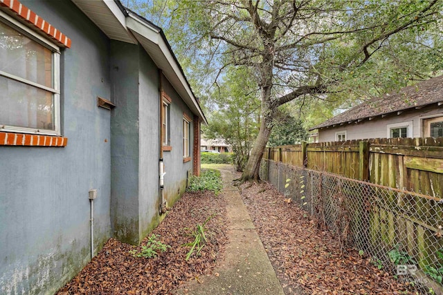 view of property exterior featuring fence and stucco siding