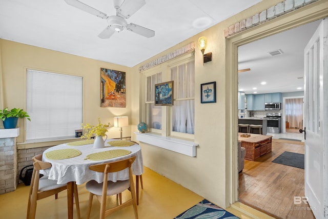 dining room with ceiling fan, wood finished floors, visible vents, and recessed lighting