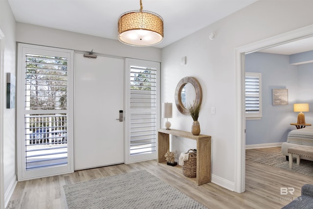 foyer with light wood-type flooring and baseboards