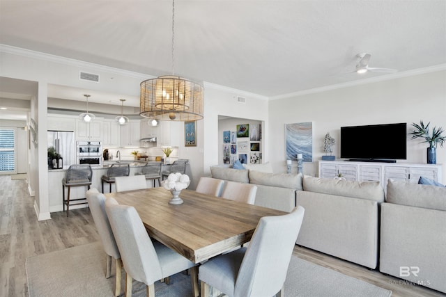 dining space featuring crown molding, visible vents, and light wood finished floors