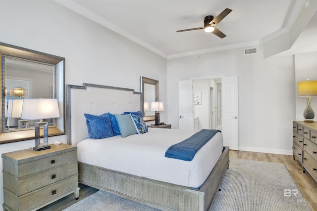 bedroom with visible vents, crown molding, baseboards, and wood finished floors