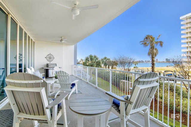 balcony featuring a water view and ceiling fan