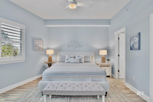 bedroom featuring baseboards, light wood-style floors, and ceiling fan