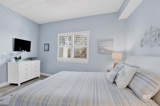 bedroom featuring baseboards and wood finished floors