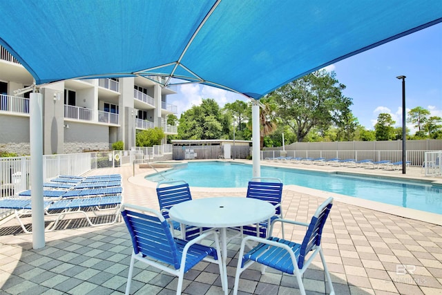 pool with a patio and fence