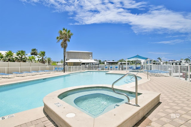 pool with a patio, a community hot tub, and fence