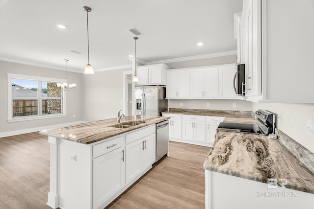 kitchen featuring an island with sink, appliances with stainless steel finishes, white cabinetry, pendant lighting, and a sink