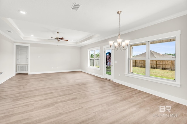 interior space with visible vents, baseboards, light wood-type flooring, a tray ceiling, and crown molding