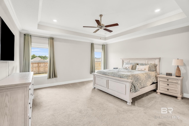 bedroom featuring baseboards, ornamental molding, a raised ceiling, and light colored carpet