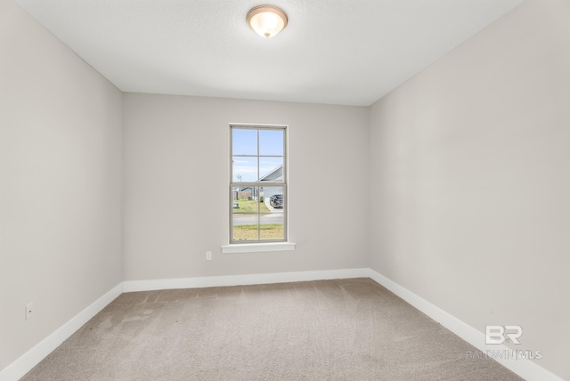 empty room with carpet and baseboards