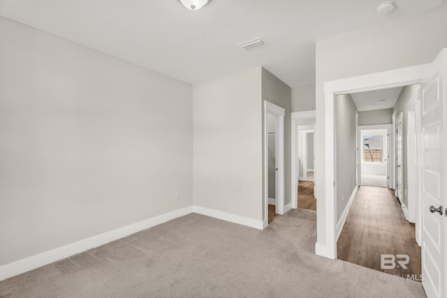 empty room with light carpet, baseboards, and visible vents