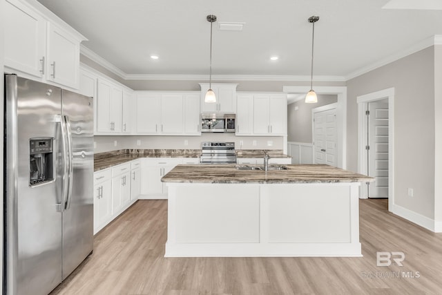 kitchen featuring stainless steel appliances, hanging light fixtures, an island with sink, and white cabinetry