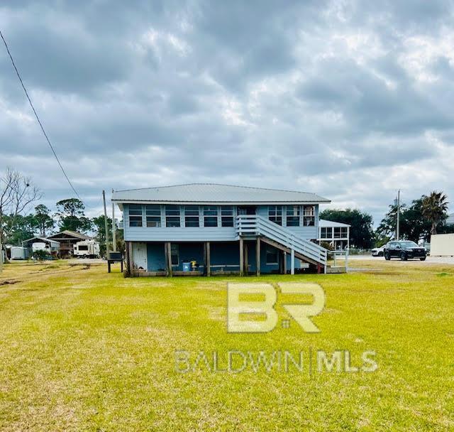 back of property featuring a sunroom and a lawn