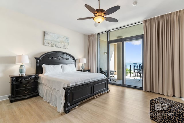 bedroom with expansive windows, access to outside, baseboards, and light wood-style floors