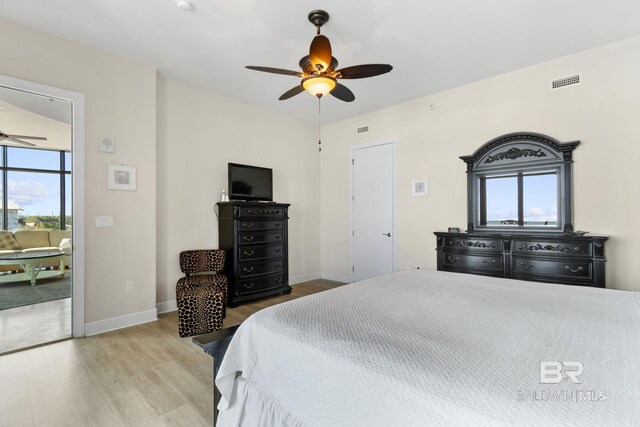 bedroom with baseboards, visible vents, and wood finished floors