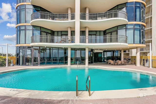 pool with a patio area and fence