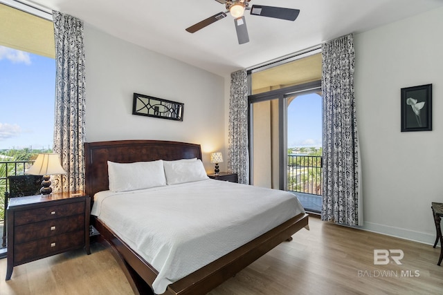 bedroom featuring access to outside, wood finished floors, a ceiling fan, and baseboards