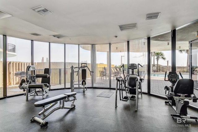 gym featuring visible vents and a wall of windows