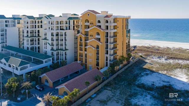 view of building exterior with a water view and a beach view