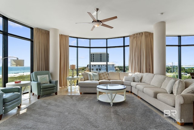 living area with expansive windows and ceiling fan