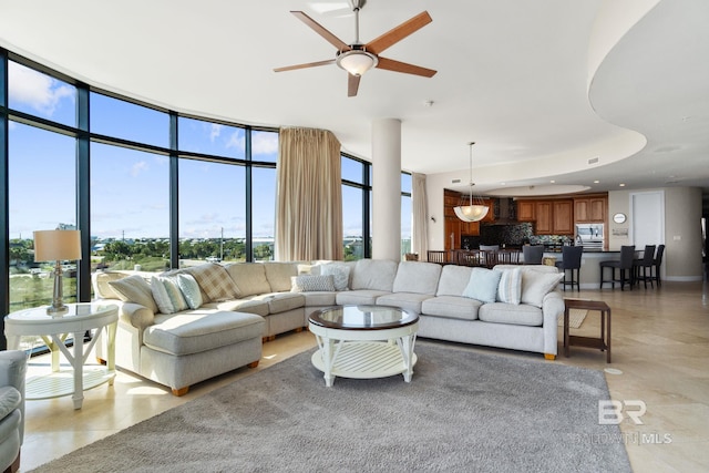 living room with ceiling fan and floor to ceiling windows