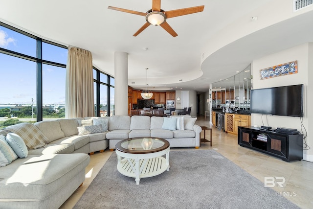 living room featuring light tile patterned floors, visible vents, a raised ceiling, a ceiling fan, and recessed lighting