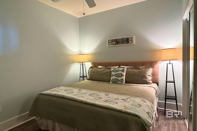 bedroom featuring wood finished floors, a ceiling fan, and baseboards